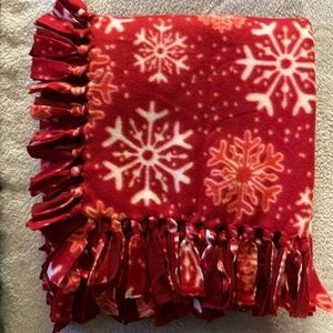 50x60” fleece tie blanket. Snowflake pattern fleece with red fleece backing.